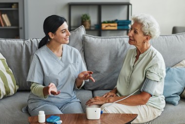 Professionnelle de santé accompagnant une personne âgée à domicile : futur modèle des Maisons France Autonomie